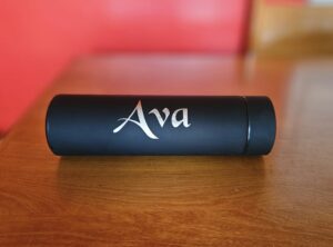 Personalized black bottle printed with name Ava, custom branding example of promotional merchandise